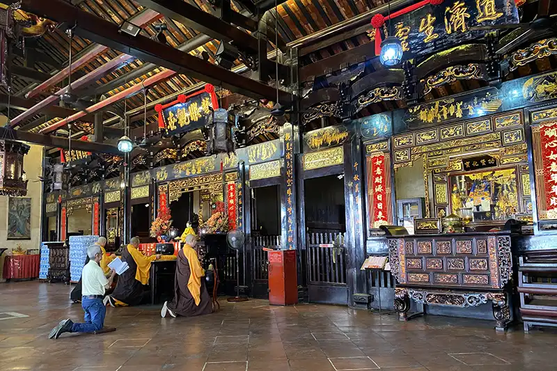 The Ultimate Guide To The 10 Best Day Trips from Kuala Lumpur (Local Expert Edition) 4 Inside Cheng Hoon Teng Temple in Malacca with monks and visitors praying during a cultural day trips from Kuala Lumpur.