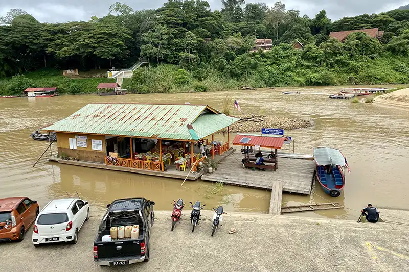Kuala Tahan Jetty with floating restaurant and boats on the Tembeling River, gateway to Taman Negara National Park.